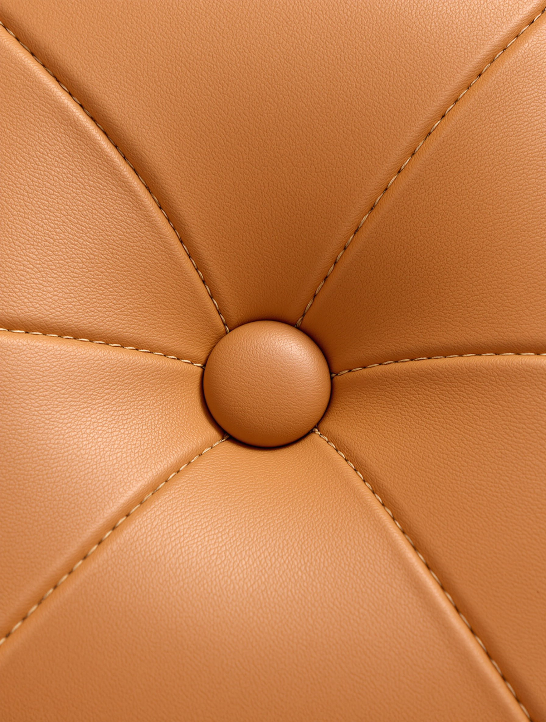 Gros plan sur le capitonnage d’un coussin du fauteuil Barcelona : texture du cuir pleine fleur, couture droite et bouton central bombé.