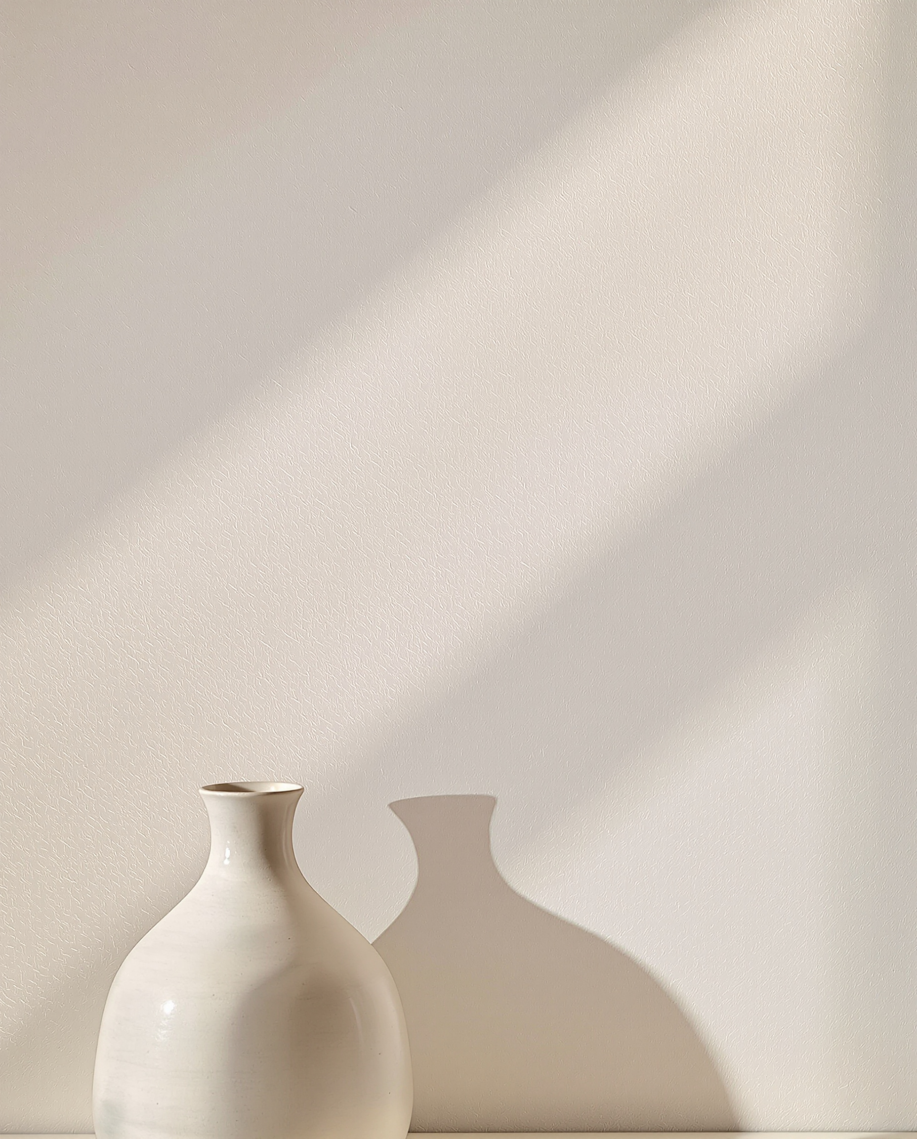 Enduit minéral clair type travertin avec vase en céramique brute